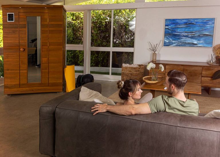 young couple sitting on couch with new sauna