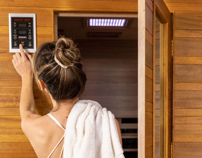 woman with her back to us turning on her health mate infrared sauna